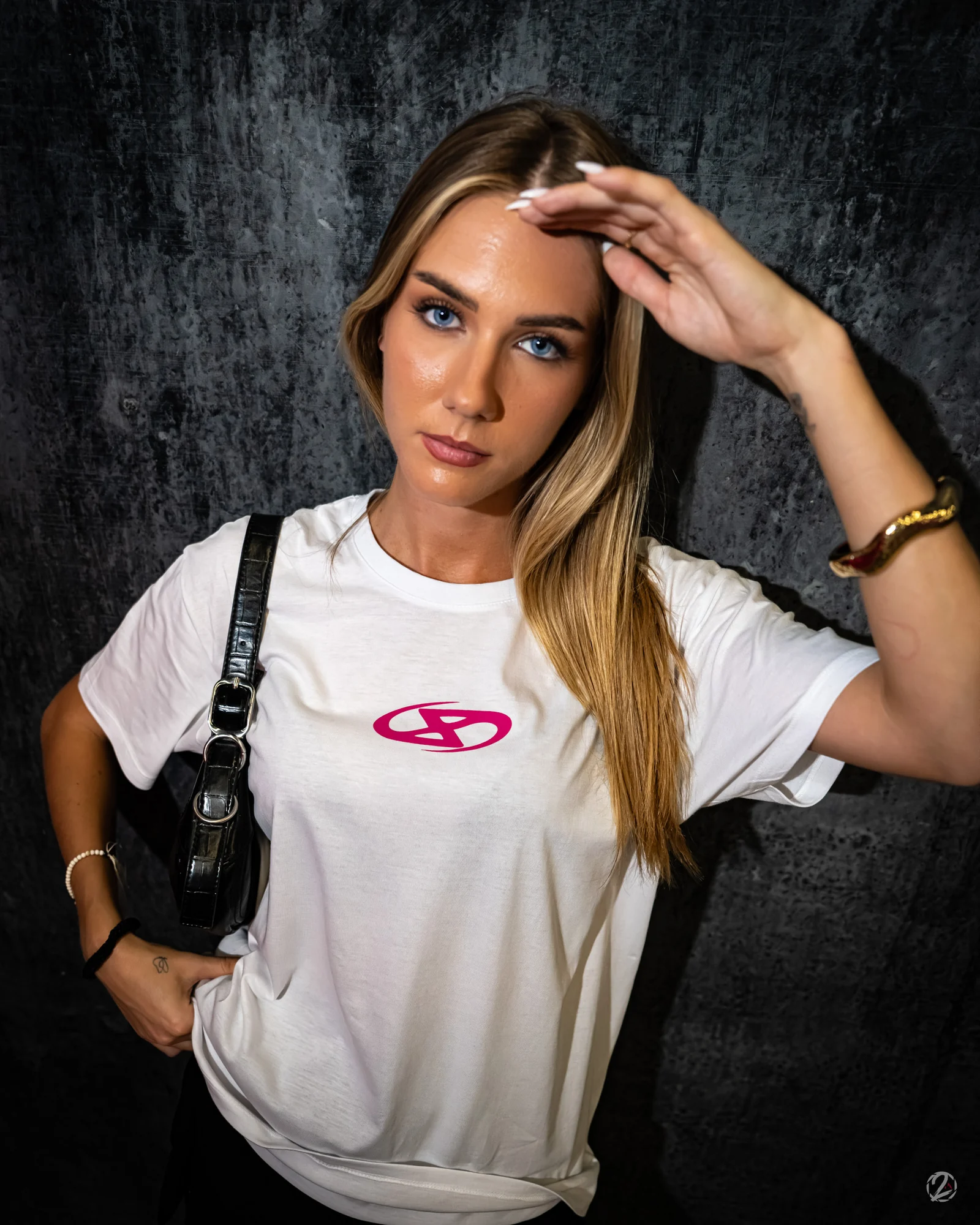 Portrait en tee-shirt blanc, une main levée au-dessus du visage.